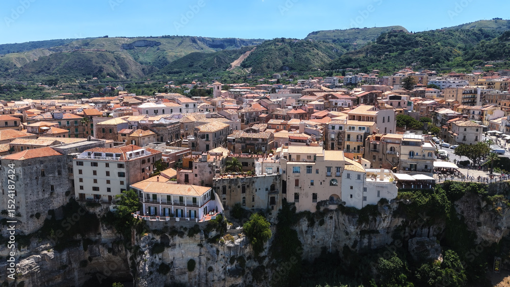 Fototapeta premium Aerial view of Tropea, a charming town perched on a cliff overlooking the Tyrrhenian Sea in Calabria, Southern Italy, featuring colorful houses and stunning coastal scenery