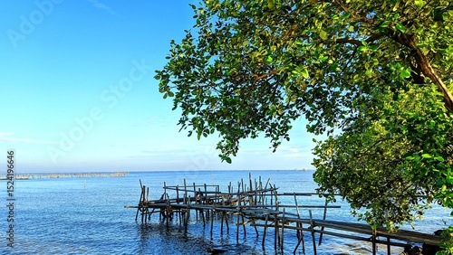 Cuadro en lienzo Scenic view of calm blue sea with bamboo bridge under shady tree at Alar Beach,