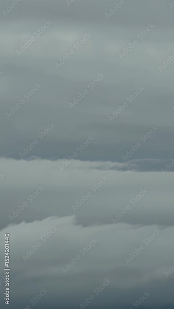 Overcast sky with layered clouds, hinting at distant mountains under a gray atmosphere Overcast sky with layered clouds, hinting at distant mountains under a gray atmosphere