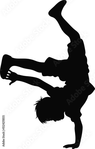 Silhouette of a young boy performing a handstand with legs and arms extended in a dynamic pose