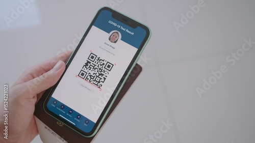 A person is holding a phone with a red passport on it. The phone is displaying a message that says 