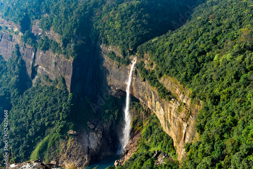 Dramatic Nohkalikai Falls plunging into a clear pool amidst lush green cliffs of Meghalaya.