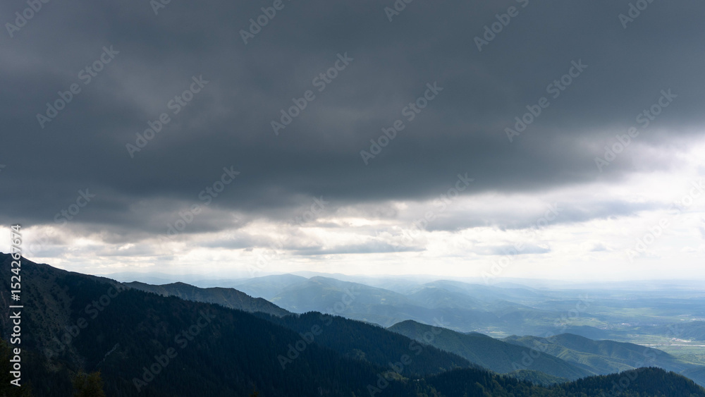 Fototapeta premium top view from mountain ladder landscape with clouds in summer carpathians romania with lights below clouds and green forests