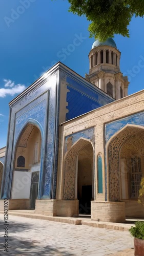 Islamic architectural complex with blue dome and tiled arches under blue sky