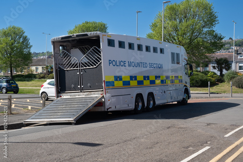 A police horsebox parked up at the side of a road with the tailgate open