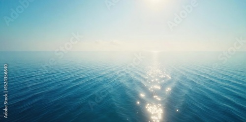 Vast, endless ocean meeting the hazy horizon line Sunlight glints on the calm water, creating a serene and peaceful atmosphere Perfect for travel, nature, or tranquility themes , waterfront, sun