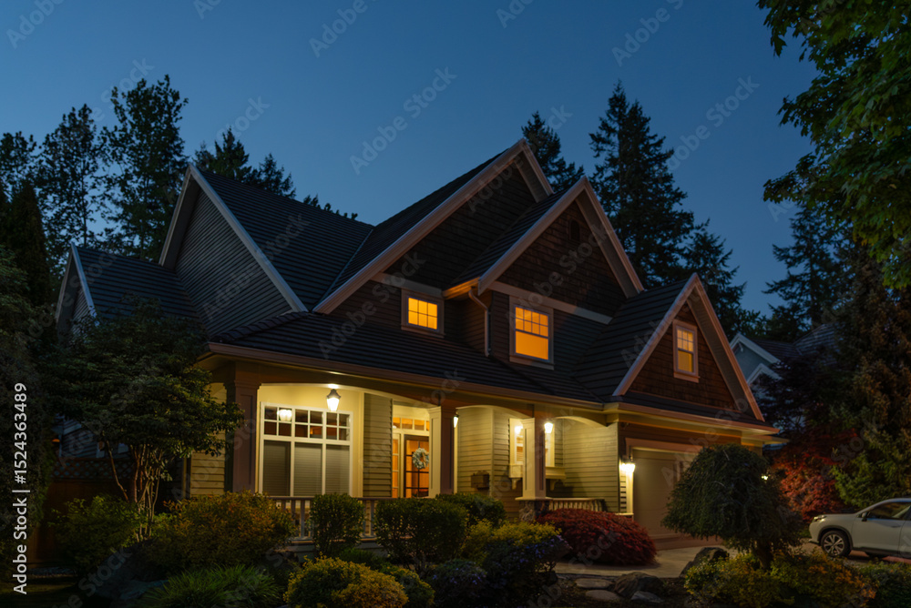 Fototapeta premium Two story stucco luxury house with nice Spring blossom landscape at night in Vancouver, Canada, North America. May 2025.