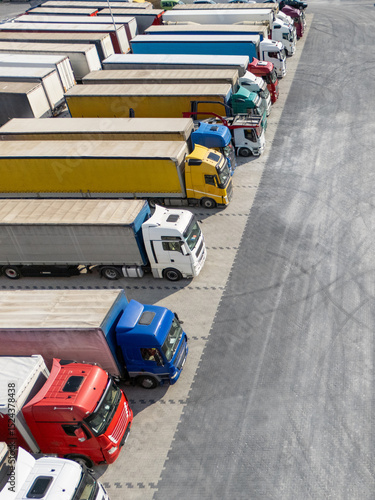 Aerial view of a large truck parking lot at a logistics hub, with multiple commercial semi trucks parked in organized rows