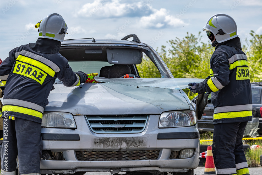 Fototapeta premium A firefighter from the rescue team cuts out a car windshield,