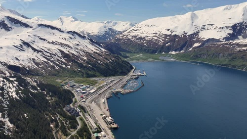 360° right turn, 4k aerial video footage of mountain landscape around Whittier, Alaska, with Cityscape, Harbour, Ferry Terminal and snow covered mountain peak surrounding the 