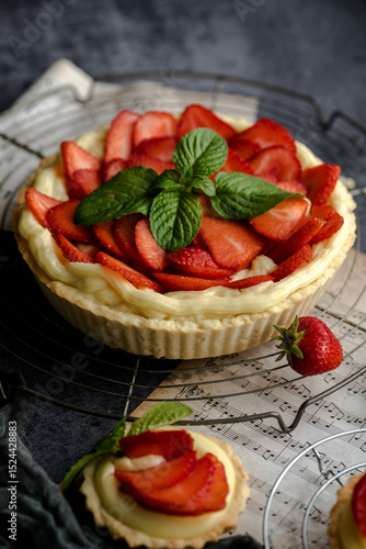 Homemade Strawberry Tart with Cream and Mint on Rustic Background