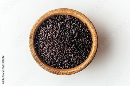 Black rice in a wooden bowl isolated on white background, a healthy and nutritious grain