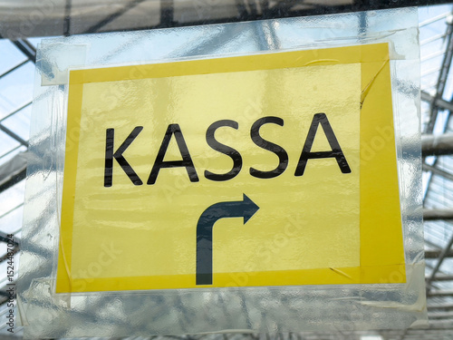 Photos Yellow kassa sign with arrow in greenhouse setting