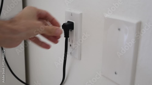hand put electric plug to outlet