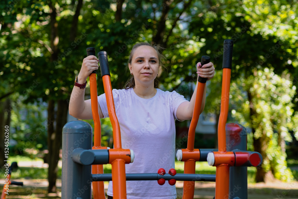Fototapeta premium Woman Working Out on Outdoor Exercise Equipment in the Park