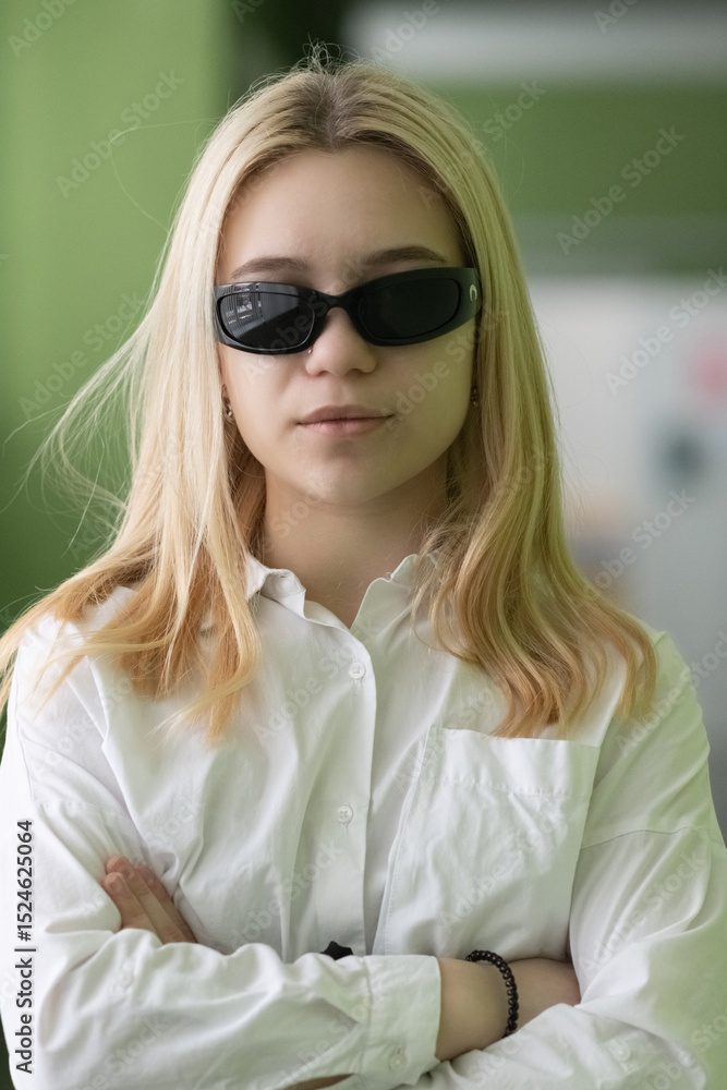 Naklejka premium Portrait of a young beautiful blonde girl in a hat in a dark room.