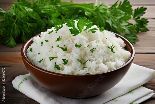 Top view of delicious rice and parsley in a bowl on white wooden table