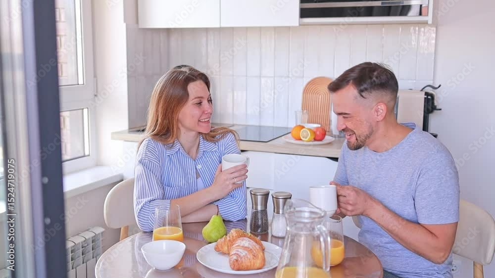 A husband and wife create a loving breakfast ritual with fresh croissants and orange juice in their cozy kitchen. Concept: cooking classes, family restaurants, relationship blogs. A husband and wife create a loving breakfast ritual with fresh croissants and orange juice in their cozy kitchen. Concept: cooking classes, family restaurants, relationship blogs.