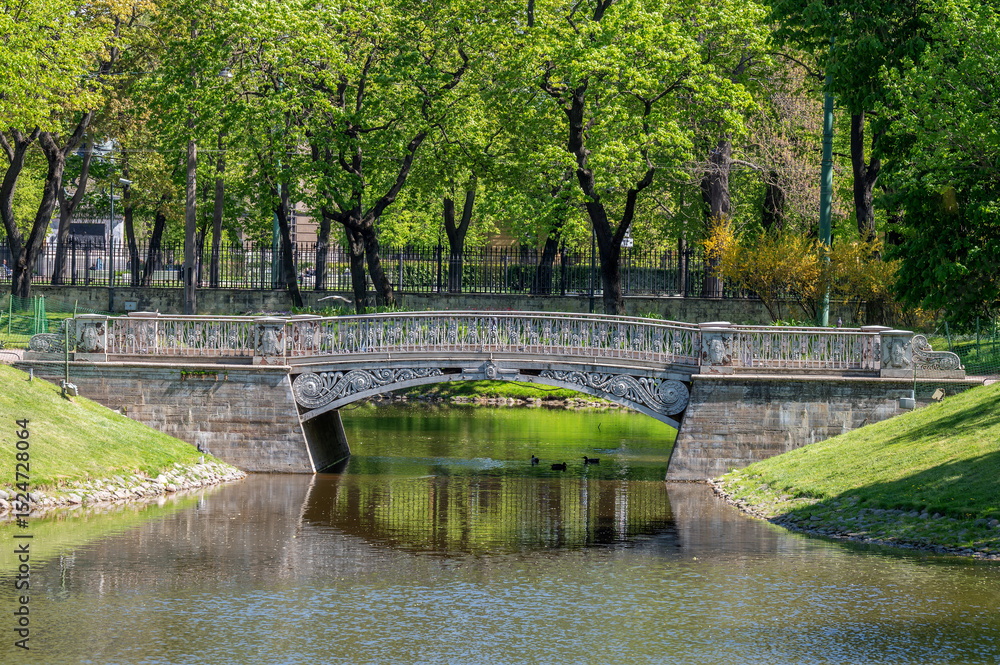 Fototapeta premium Cast iron pedestrian bridge in the city park.
