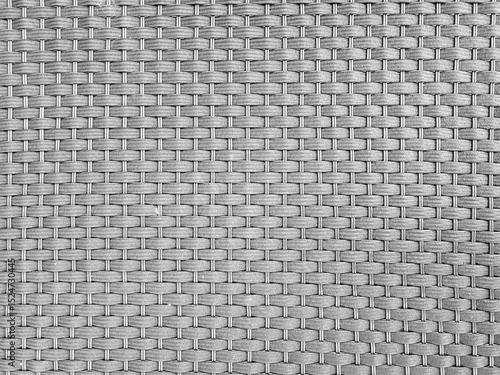 Close-up of a grey woven rattan pattern forming a seamless geometric texture. Ideal for use in furniture, backgrounds, or interior design visuals.