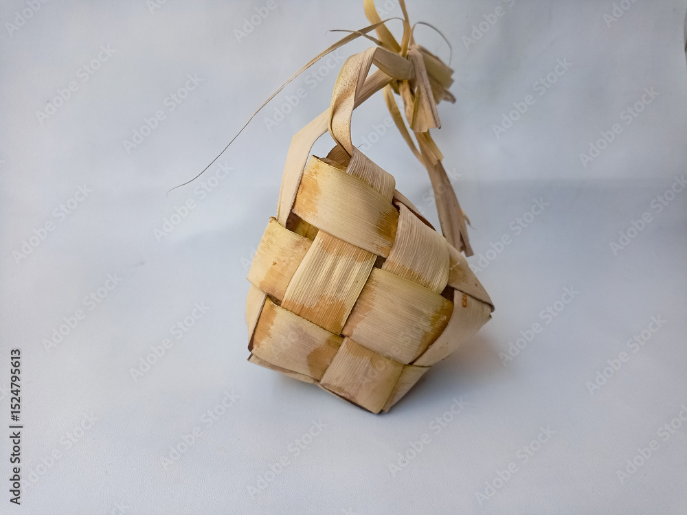 Fototapeta premium Ketupat an Indonesian traditional cuisine very popular during Hari Raya Idul Fitri isolated on a white Background. This is made of the white rice, usually served with opor ayam on Ied day.