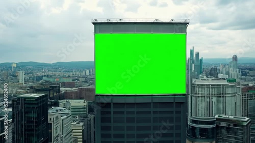 Green Screen on a Billboard Mounted on City Building for Urban Advertising Mockup