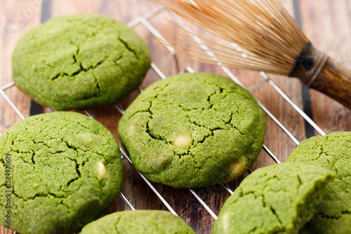 Chewy matcha chocolate chip cookies on cooling rack.