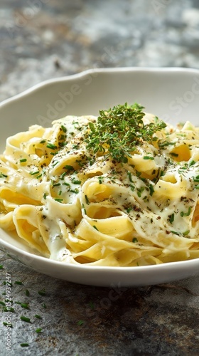 Creamy Fettuccine Pasta Topped With Herbs Served in an Elegant Restaurant Set...