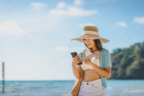 Happy asian traveler woman relax and use mobile phone for selfie on sea beach at day in Koh Kood Trat Thailand Travel summer holiday vacation concept