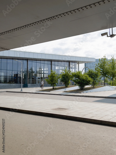 A large building with a lot of windows and a green area in front of it