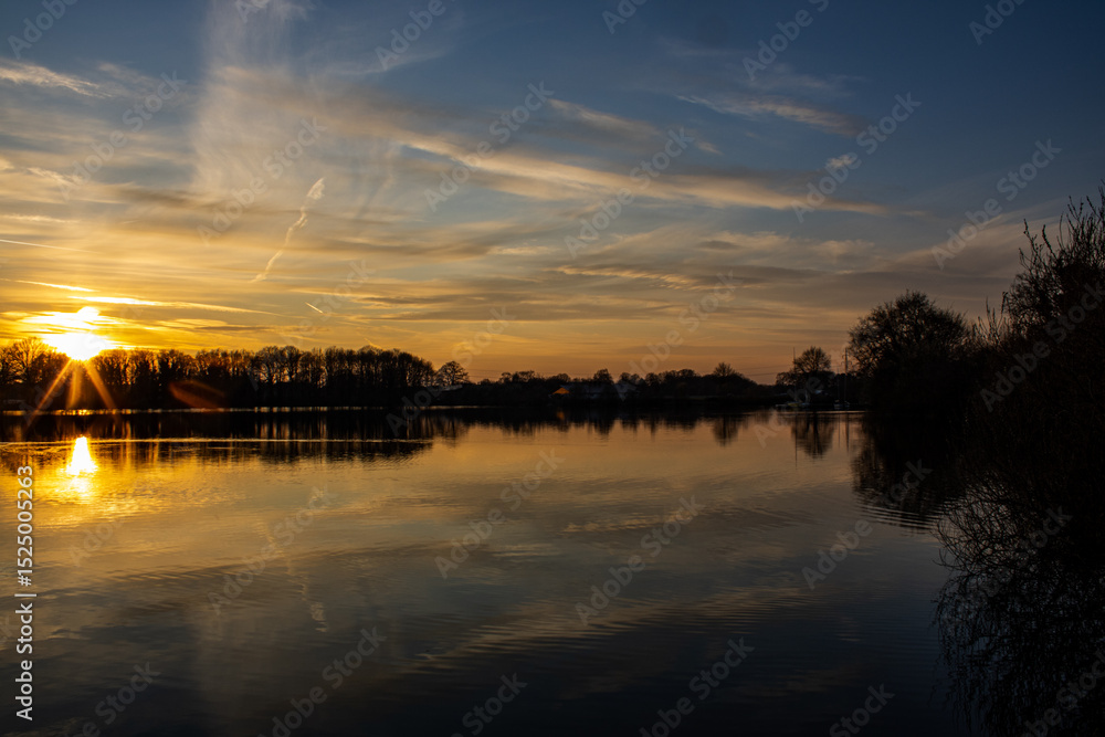 Obraz premium Sunset on a calm lake, with reflection in the water