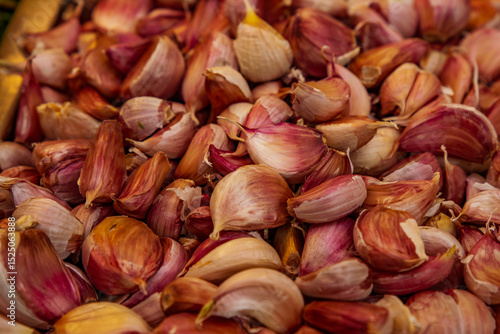 Fresh garlic bulbs at the Central Market of Valencia, Spain, creating a rustic textured background. Perfect high-quality image for travel, gastronomy, and cultural projects. Showcasing Mediterranean c