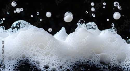 Dynamic close-up of bubbles in white foam background with dark contrast