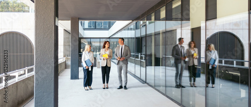 Business team discussing contract terms outside modern office building