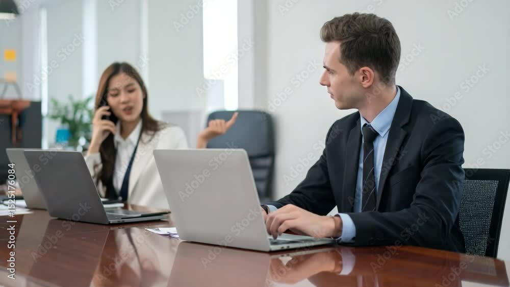 Strategic Dialogue: A focused man working on a laptop, collaborating with a woman. Their business meeting unfolds with a calm and professional atmosphere. Strategic Dialogue: A focused man working on a laptop, collaborating with a woman. Their business meeting unfolds with a calm and professional atmosphere.