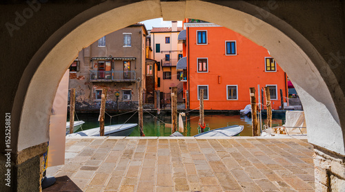 Fototapeta Naklejka Na Ścianę i Meble -  Chioggia, Italien, Blick durch den Torbogen auf den Kanal und die bunten alten Häuser