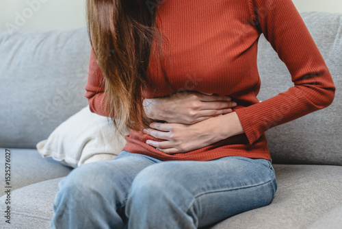 Fotografija asian young woman intolerance hand in stomach ache, suffer from food poisoning,