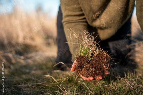 Foto regenerative organic farmer, working with cows on a cattle farm in the yards and field while also studying soil samples and looking at plant growth in a farm