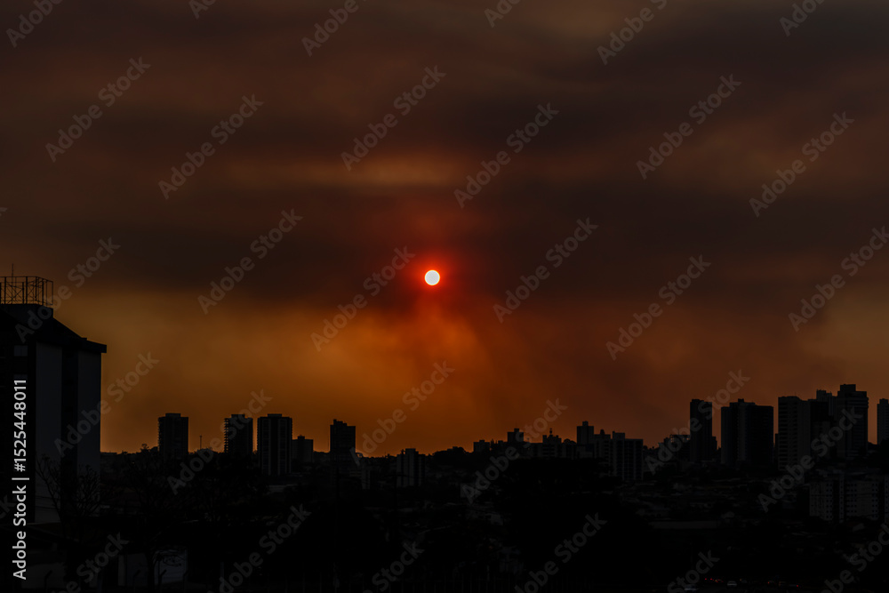 Fototapeta premium Afternoon with orange sky, the result of the massive presence of soot and pollutants in the atmosphere, low air humidity, high temperatures, smoke and fire