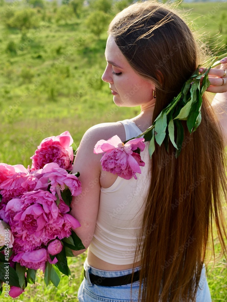 Fototapeta premium Happy smiling woman outdoors with pink peony flowers enjoying life in the moment at sunset