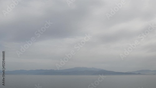 Experience tranquil beauty of Greece islands in stunning time lapse landscape view showcasing shifting clouds, calm waters, and breathtaking mountains enveloped in twilight.