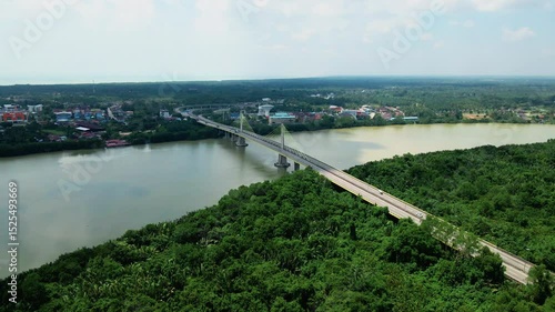 Wallpaper Mural Aerial view of a long cable-stayed bridge crossing a wide river surrounded by forest and buildings. Modern infrastructure. Torontodigital.ca