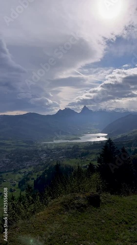 Stunning mountain landscape overlooking a serene lake under a cloudy sky during daytime