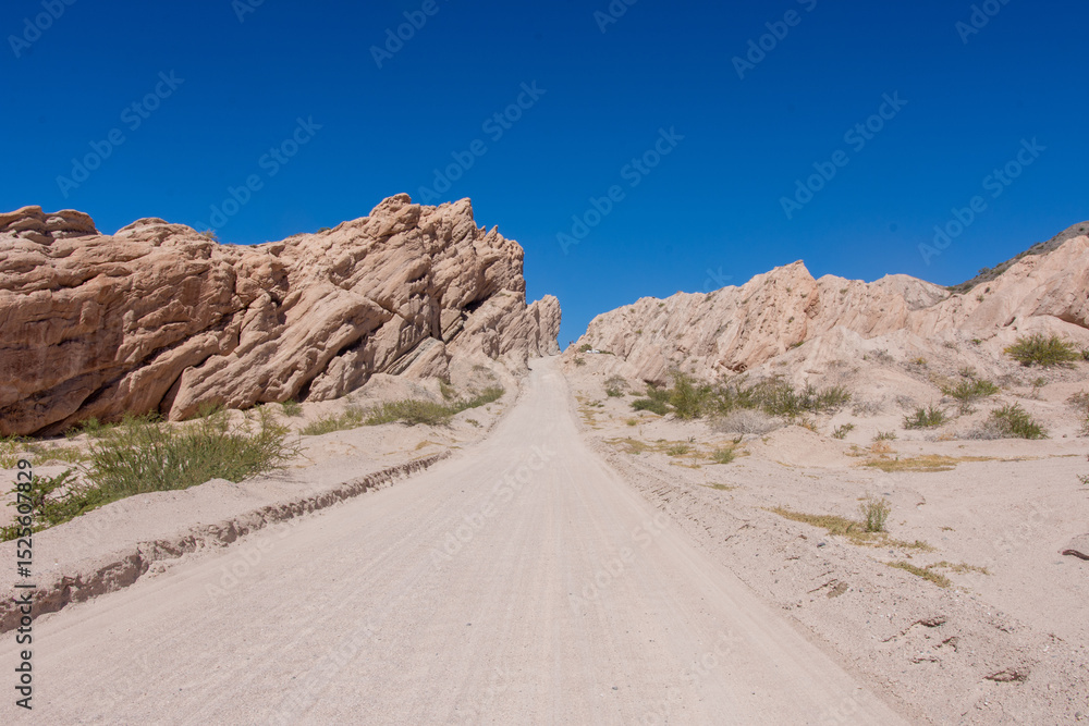 Dirt road in the desert named Quebrada de las Flechas with mountains of sedimentary rocks in Salta Province, Argentina Dirt road in the desert named Quebrada de las Flechas with mountains of sedimentary rocks in Salta Province, Argentina