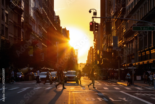 Crowded intersection with busy people and traffic on 5th Avenue in New York City with sunset light shining in the background