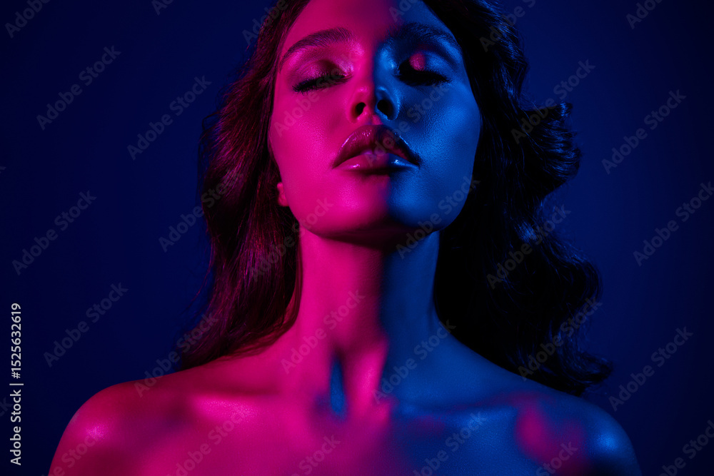 Fototapeta premium Portrait of a stunning woman with neon lighting in pink and blue hues conveying elegance, beauty, and modern style