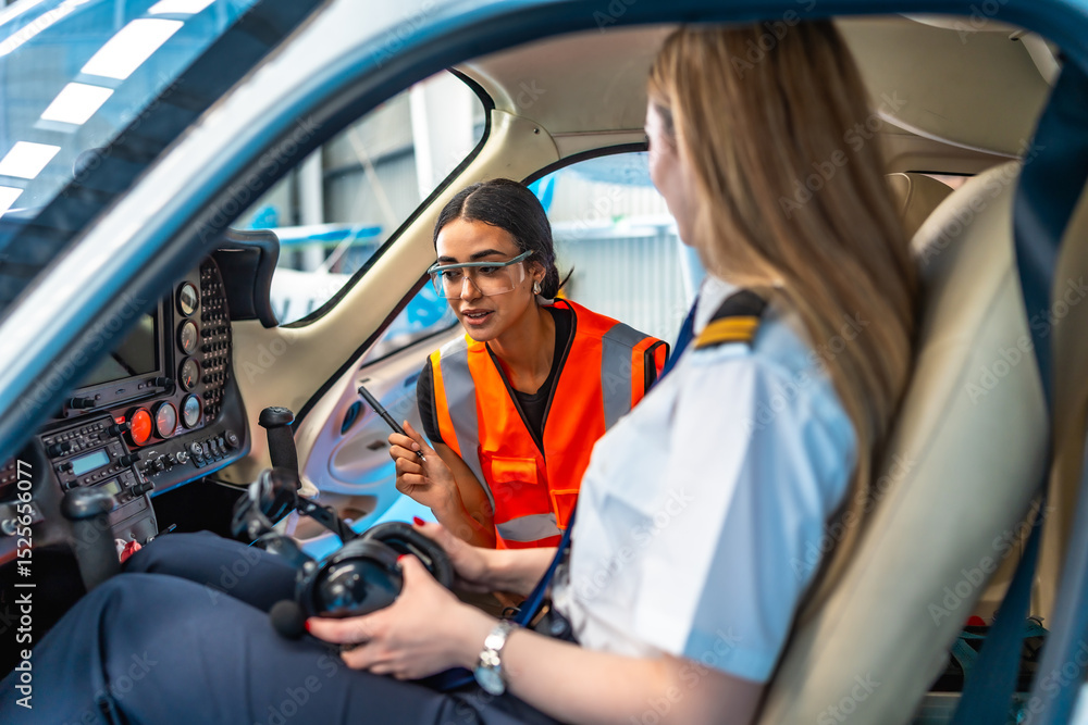 Obraz premium Aircraft maintenance engineer explaining to pilot inside cockpit
