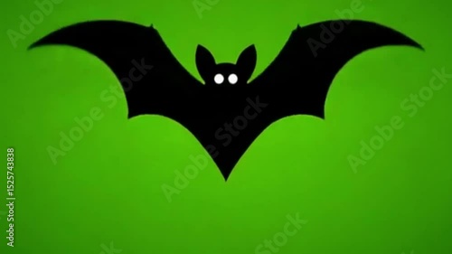 Black silhouette bat with glowing eyes against green background for halloween