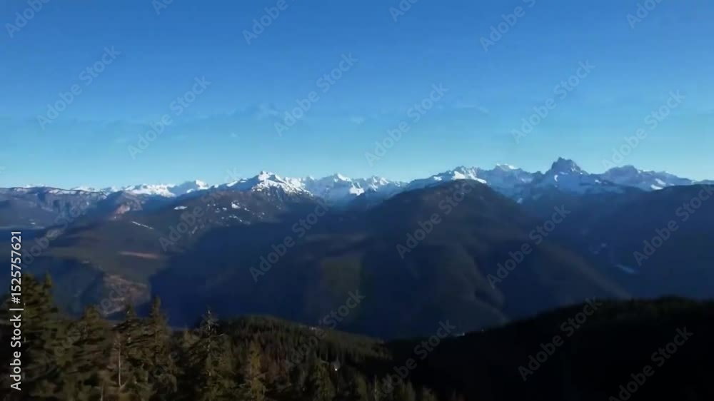 Snowy mountain range with dense forests in the valley below Snowy mountain range with dense forests in the valley below