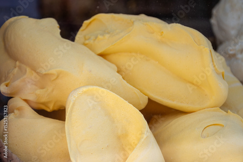 Fresh baked eggs meringues with various tastes on window display in confectionery shop in old Bruges, Belgian sweets
